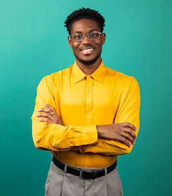 Patrick smiling facing the camera with arms crossed